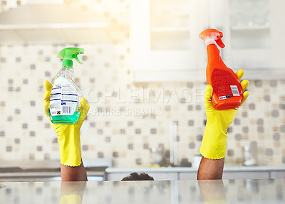 Buy stock photo Cropped shot of an unrecognizable young man holding up bottles of detergent while cleaning his home