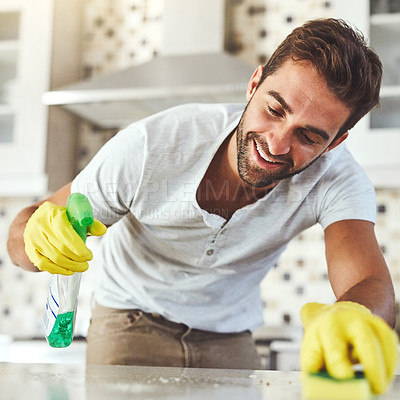 Buy stock photo Cropped shot of a handsome young man cleaning his kitchen at home