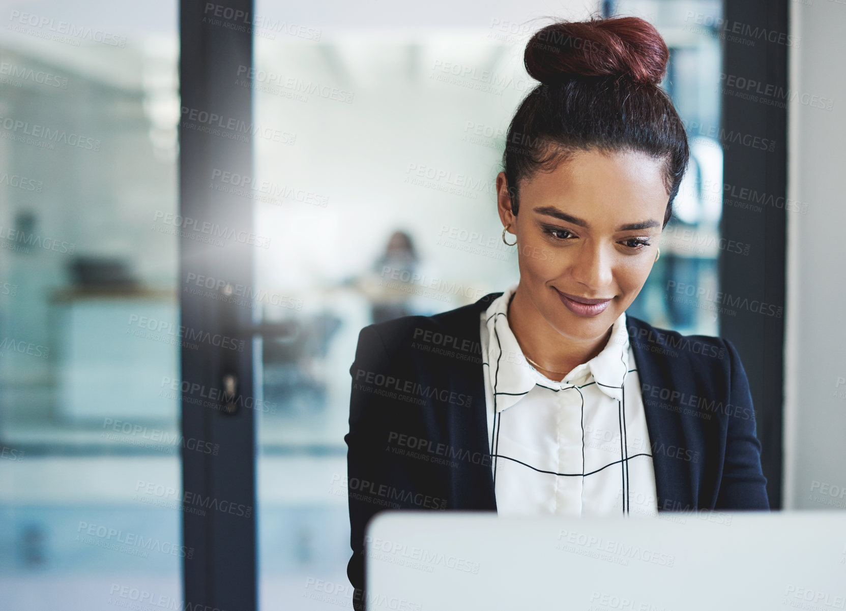 Buy stock photo Shot of a young businesswoman using a laptop in a modern office