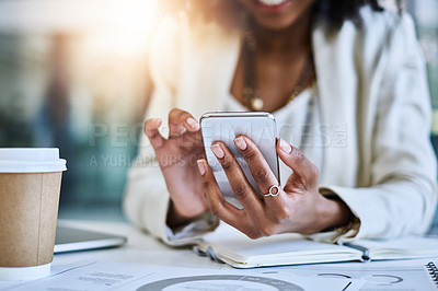 Buy stock photo Shot of an unrecognizable businesswoman using her cellphone at her office desk