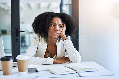 Buy stock photo Shot of a young businesswoman looking stressed out and frustrated at her office desk