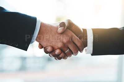 Buy stock photo Cropped shot of two unrecognizable businessmen shaking hands in an office