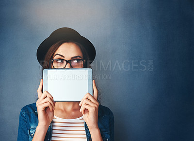 Buy stock photo Face, tablet screen and mockup with a fashion woman in studio on a blue background for social media marketing. Thinking, display and style with a young person holding empty tech for advertising space