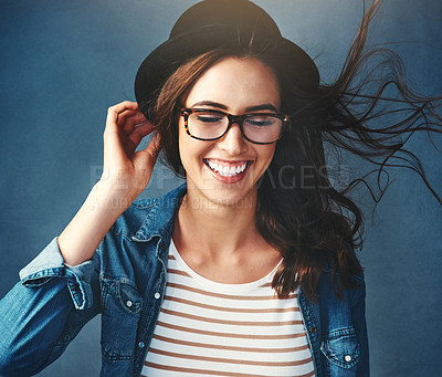 Buy stock photo Studio shot of an attractive young woman smiling against a blue background