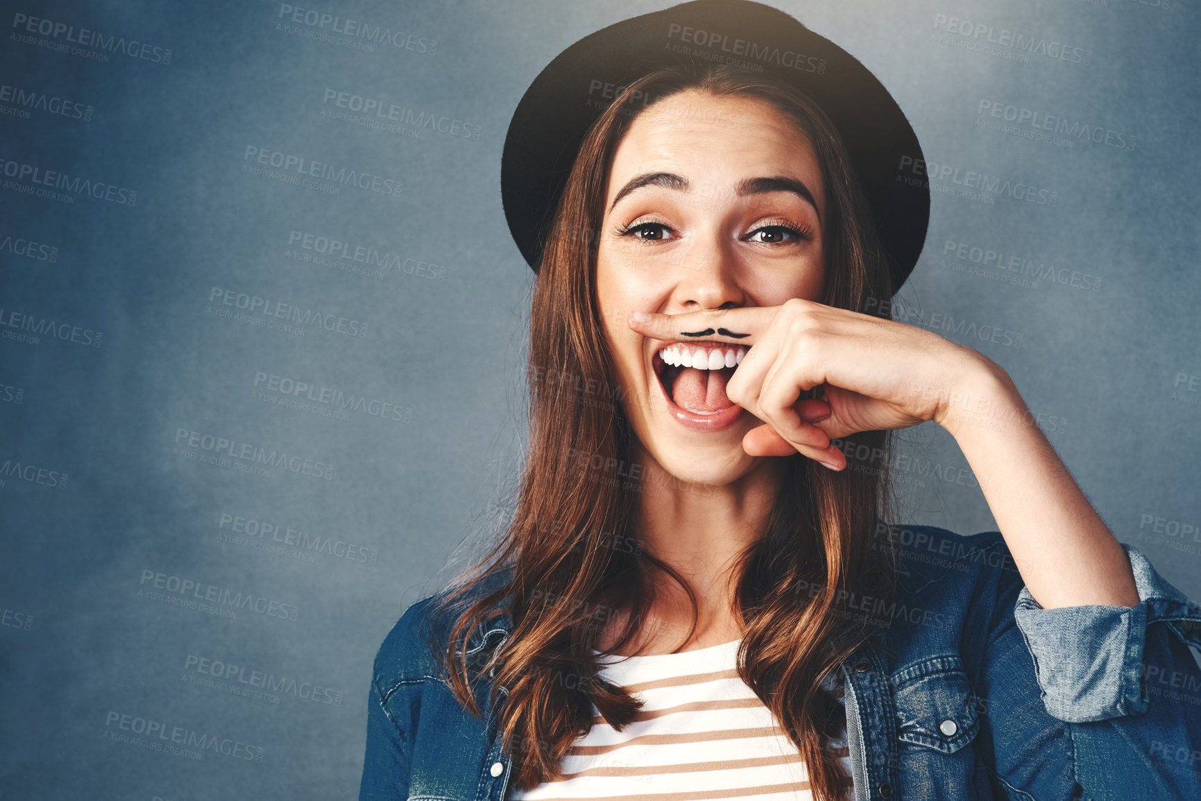 Buy stock photo Happy woman, finger and mustache in studio with portrait for quirky behavior, facial expression and funny face with hat. Silly, hand gesture and creative humor, goofy and playful on dark background.