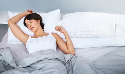 Buy stock photo Shot of a tired attractive young woman sleeping in her bed at home in the morning