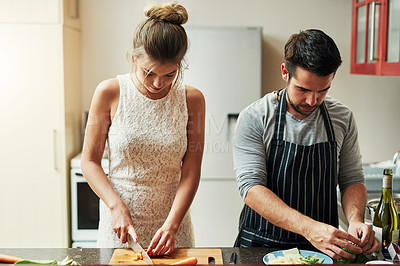 Buy stock photo Cropped shot of an affectionate young couple preparing food together at home