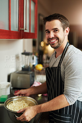 Buy stock photo Cropped portrait of a handsome young man draining pasta at home