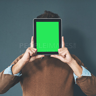 Buy stock photo Studio shot of a young man holding a digital tablet with a green screen against a grey background