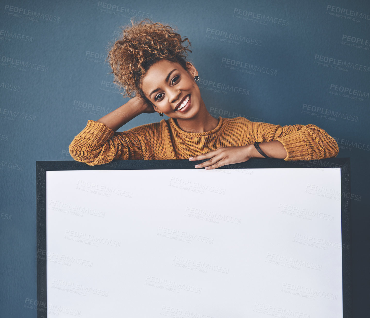 Buy stock photo Board, announcement and empty copyspace by a smiling African American young lady. Beautiful, cheerful and happy woman standing in the background behind poster. Confident black woman presenting sign.