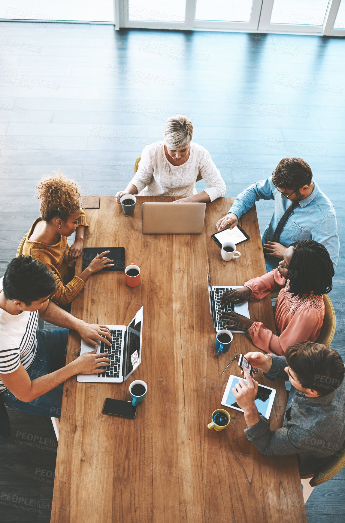 Buy stock photo Shot of a group of young businesspeople having a meeting in a modern office