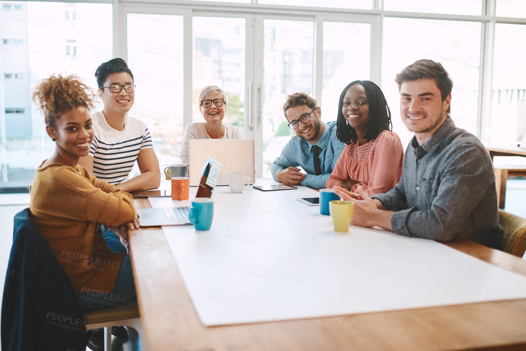 Buy stock photo Shot of a group of young businesspeople having a meeting in a modern office