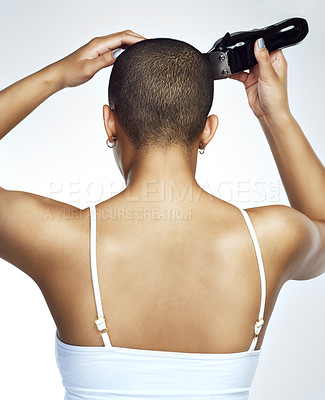 Buy stock photo Rearview shot of a young woman shaving her head against a white background