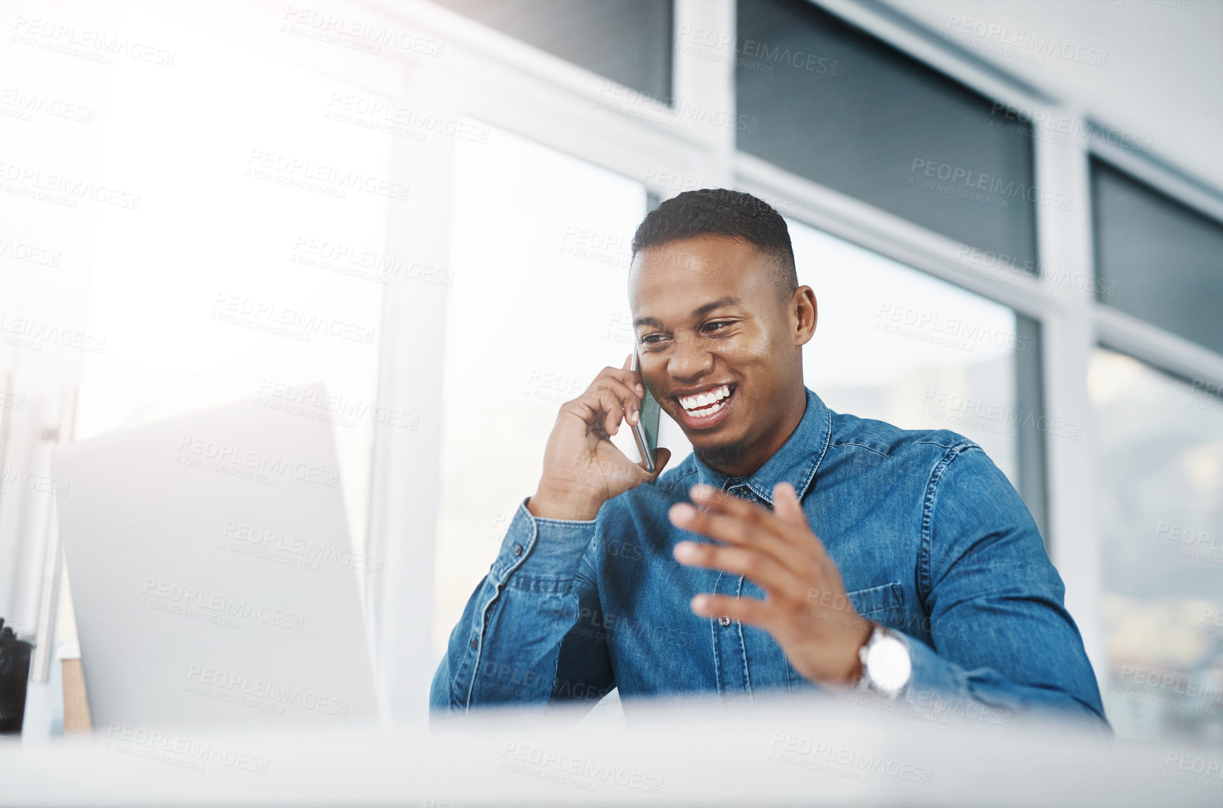 Buy stock photo Shot of a young businessman taking a phone call at his office desk