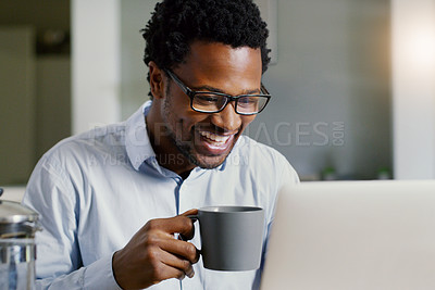 Buy stock photo Shot of a handsome young businessman working on his laptop at home