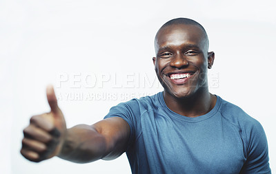 Buy stock photo Studio shot of a handsome young man posing with his thumb up against a grey background