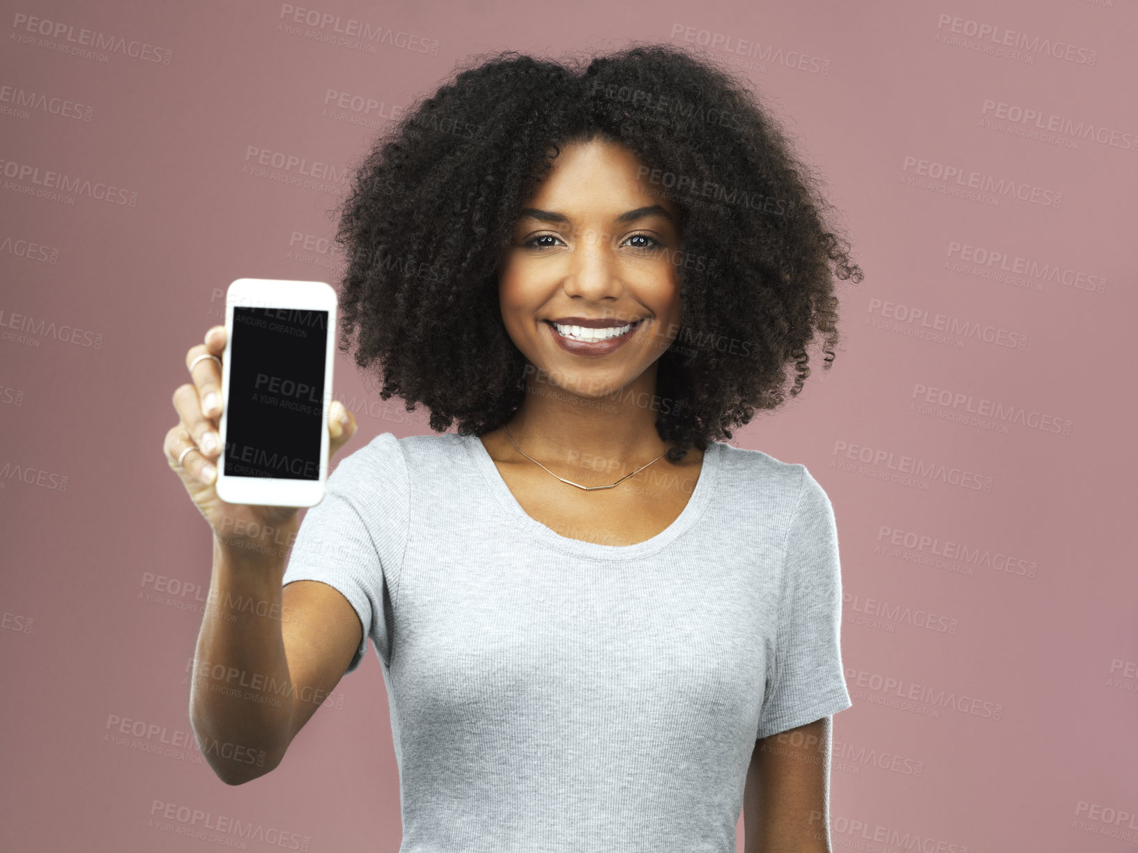 Buy stock photo Studio shot of an attractive young woman holding a smartphone with a blank screen against a pink background