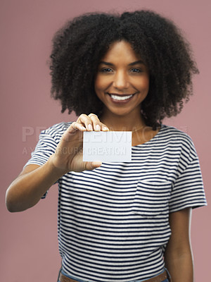 Buy stock photo Shot of a young woman holding up a blank card against a pink background