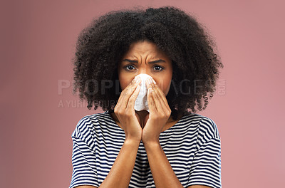 Buy stock photo Cropped shot of a young woman blowing her nose into a tissue