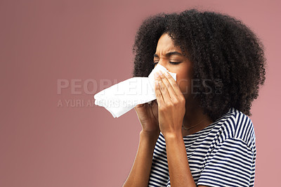 Buy stock photo Cropped shot of a young woman blowing her nose into a tissue