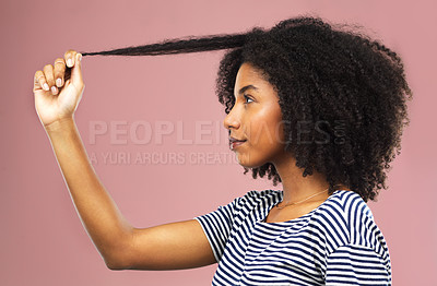 Buy stock photo Studio shot of a beautiful young woman holding up a strand of hair