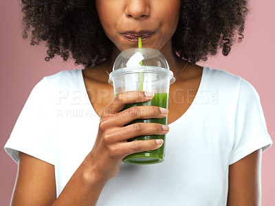 Buy stock photo Studio shot of an attractive young woman drinking green juice against a pink background