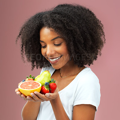 Buy stock photo Happy, woman and fruit for balanced diet, healthy choice and nutrition with vitamin on studio background. Excited, female person and smile for food detox, vegan option and weight loss for wellness