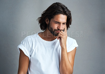 Buy stock photo Studio shot of a handsome young man looking worried against a grey background