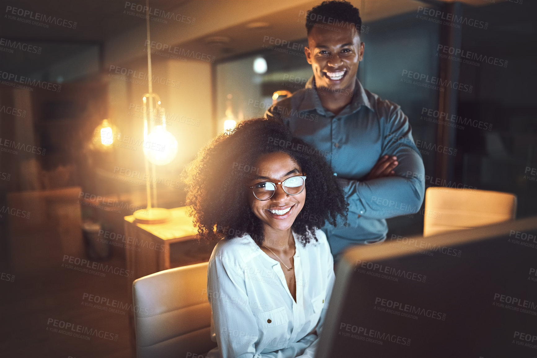 Buy stock photo Portrait of two businesspeople working together on a computer in an office at night