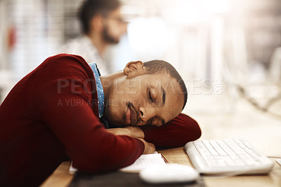 Buy stock photo Shot of a university student sleeping while working on a computer in the library on campus