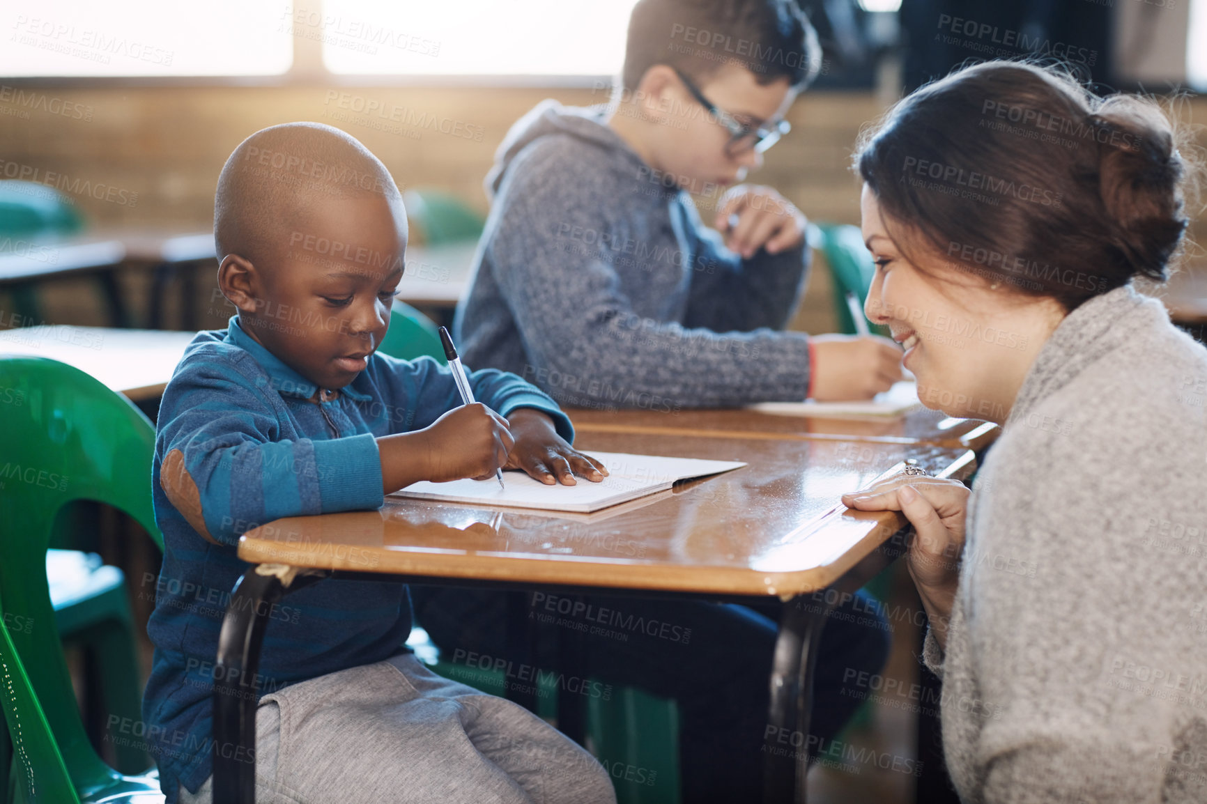 Buy stock photo Cropped shot of an elementary school teacher helping her students in the classroom