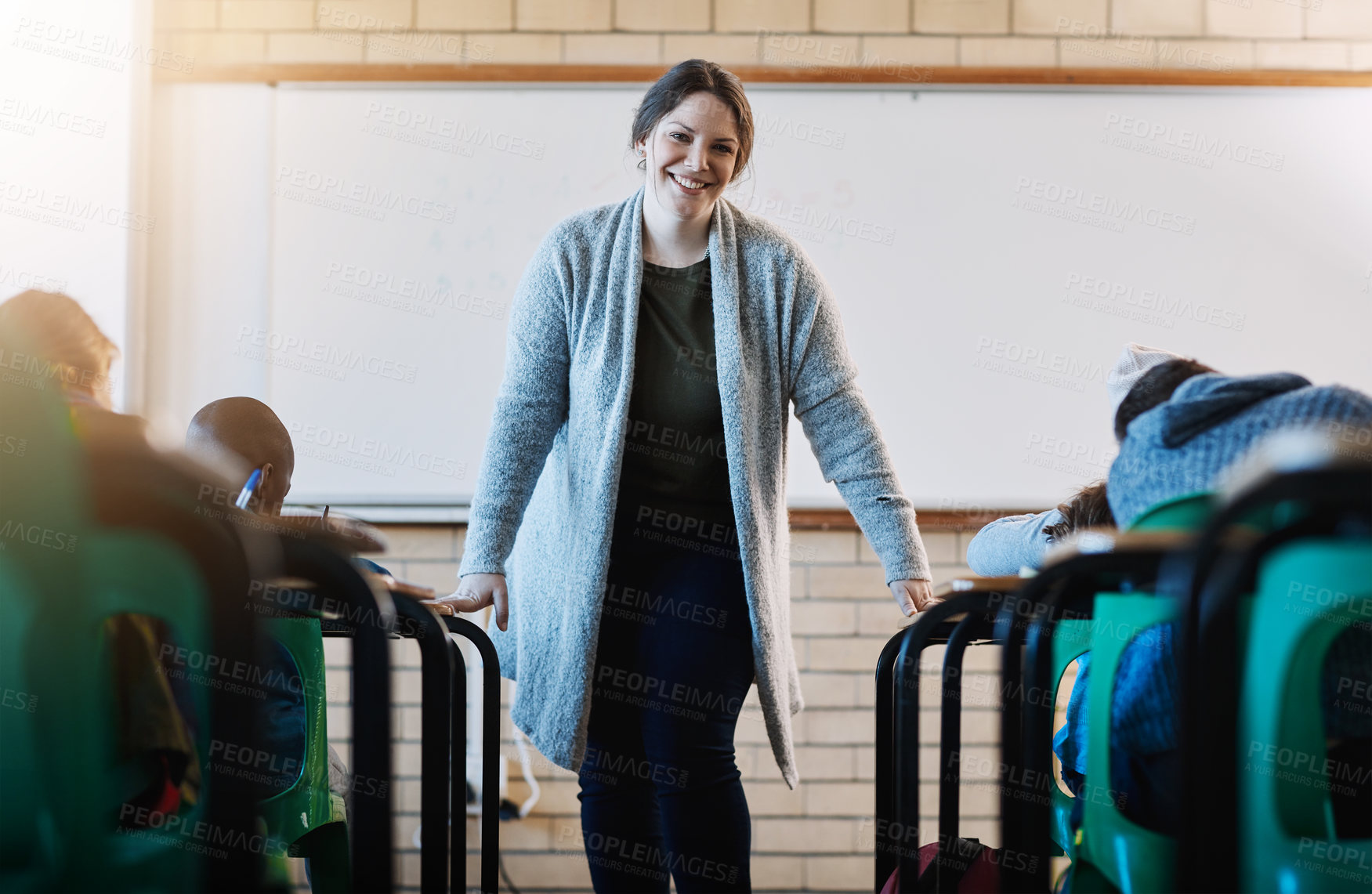 Buy stock photo Cropped portrait of an elementary school teacher standing at the head of her classroom