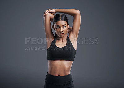 Buy stock photo Portrait, mockup and stretching with a sports woman in studio on a gray background for fitness or health. Exercise, workout and warm up with an attractive young female athlete training her body