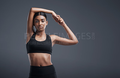 Buy stock photo Portrait, mockup space and warm up with an athlete woman in studio on a gray background for exercise or health. Fitness, workout and stretch with an attractive young female model training her body