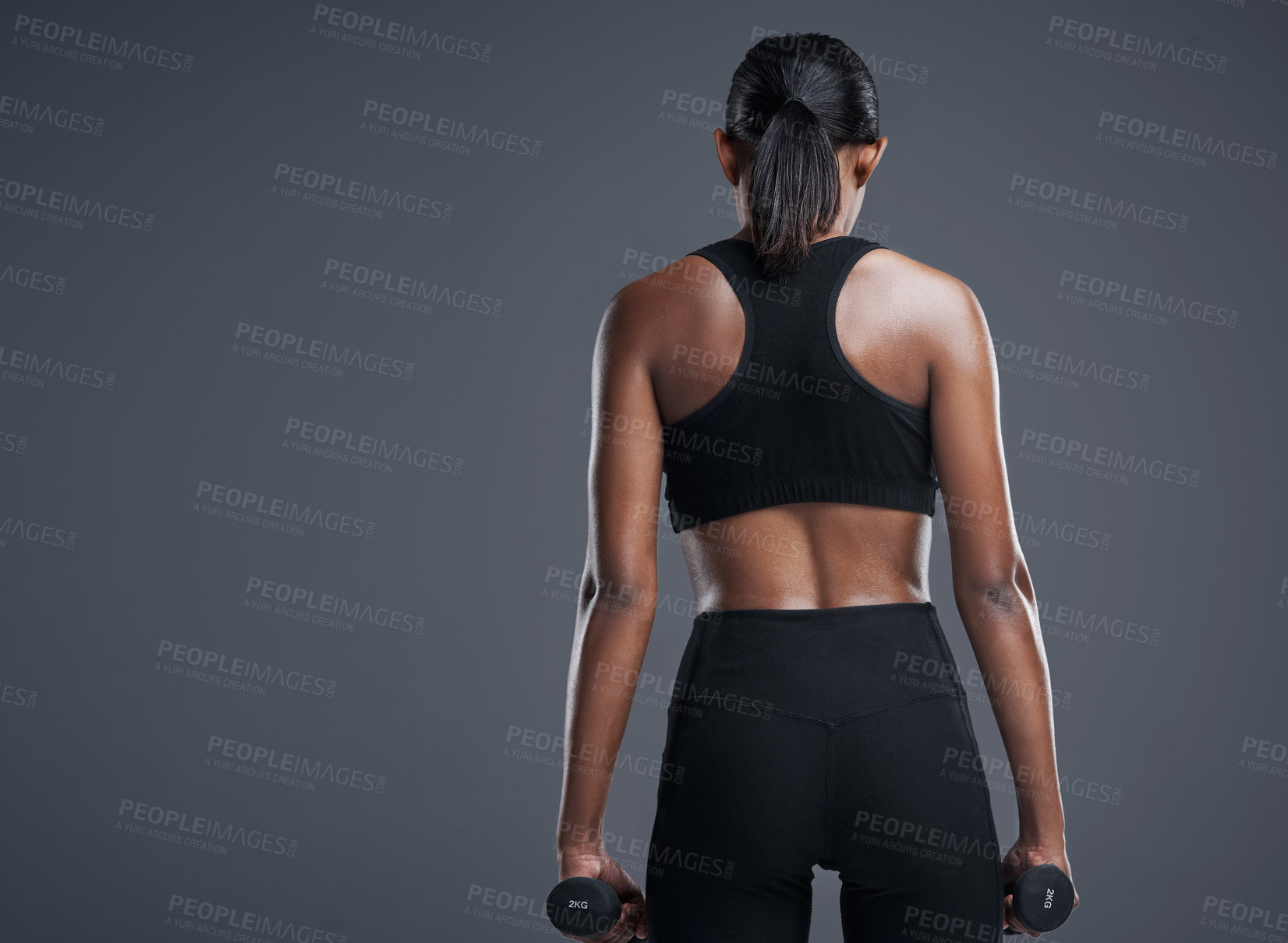 Buy stock photo Woman, dumbbells and exercise for fitness in studio on grey background for health, muscles and sportswear. Back view, workout and committed for wellbeing with weights for training, care and wellness