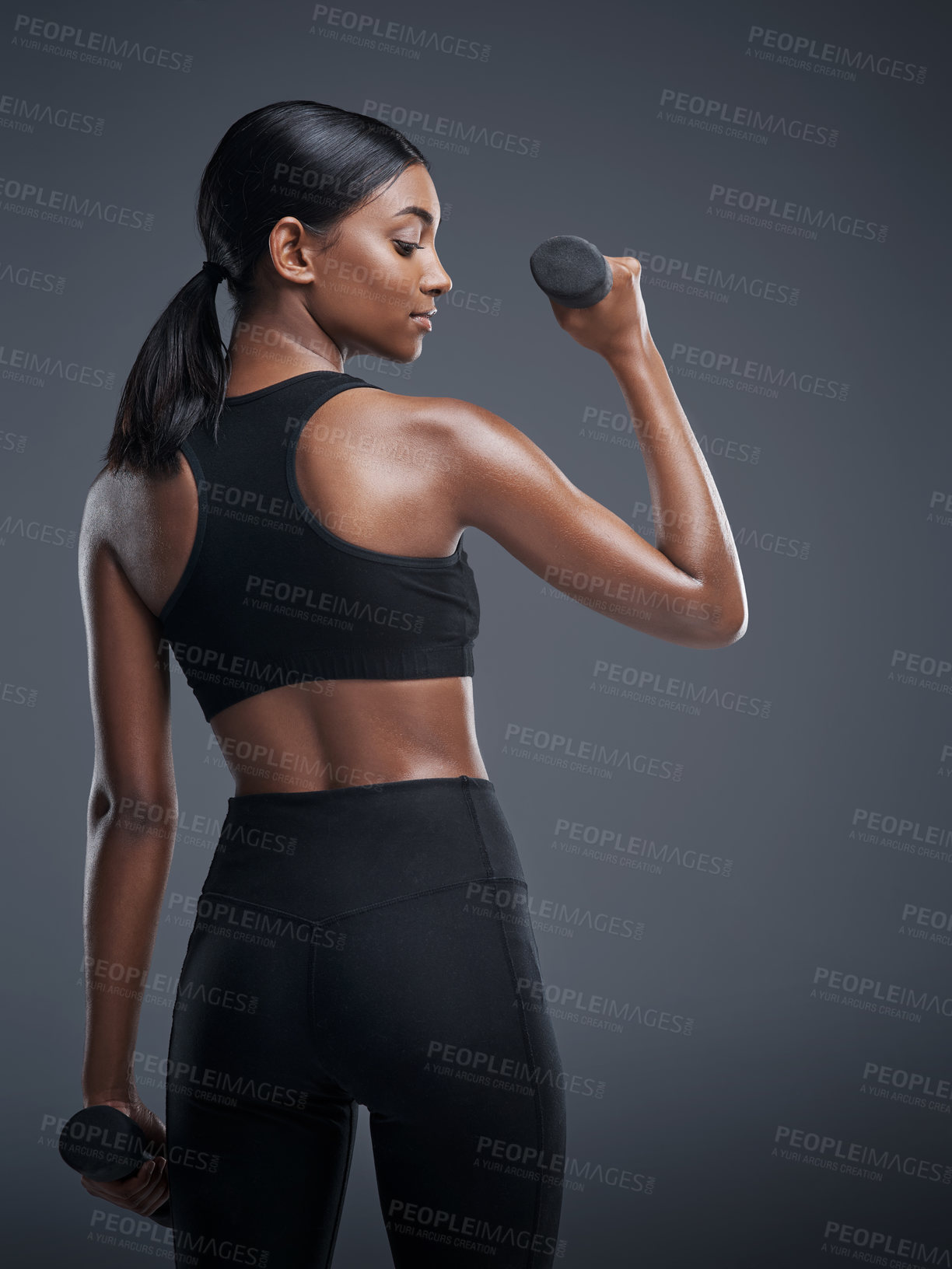 Buy stock photo Indian woman, dumbbells and workout for fitness in studio on grey background for health, muscles and sportswear. Back view, workout and committed for wellbeing with weights for training and self care