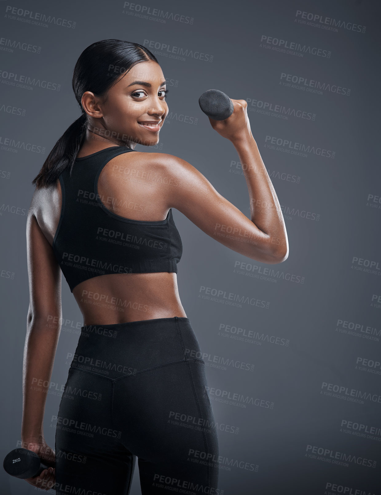 Buy stock photo Woman, dumbbells and smile for workout in studio on grey background for health, muscles and sportswear. Back view, fitness and committed for wellbeing with weights for training and self care