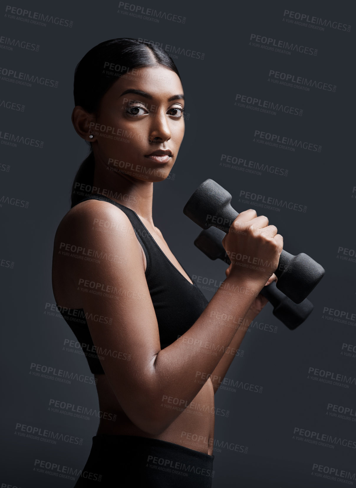 Buy stock photo Serious, portrait and woman with dumbbells for workout in studio isolated on a black background. Strong, bodybuilder and Indian female athlete weightlifting for muscle, training and fitness exercise.