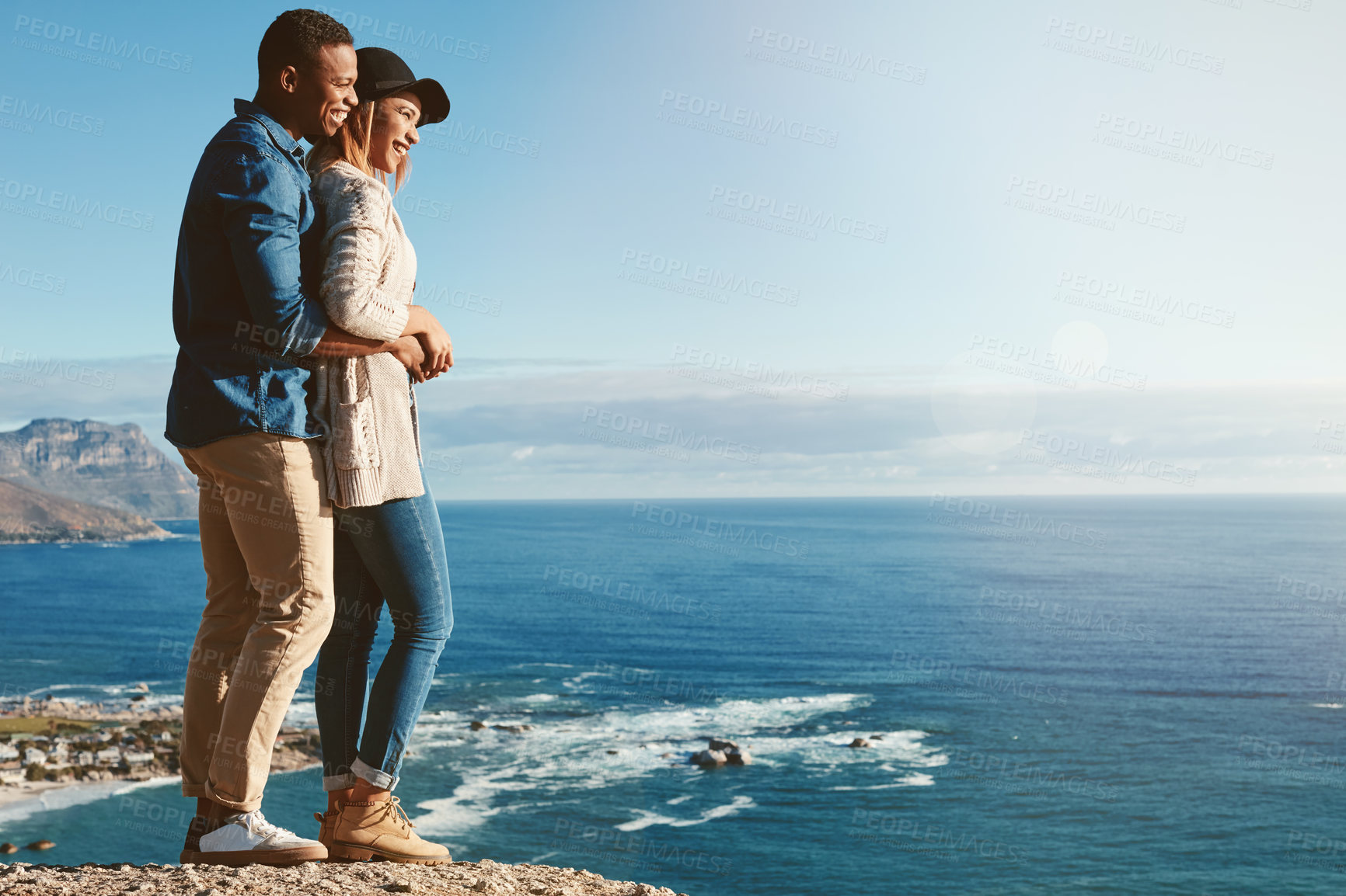 Buy stock photo Shot of a happy young couple enjoying the ocean view on a romantic day outdoors