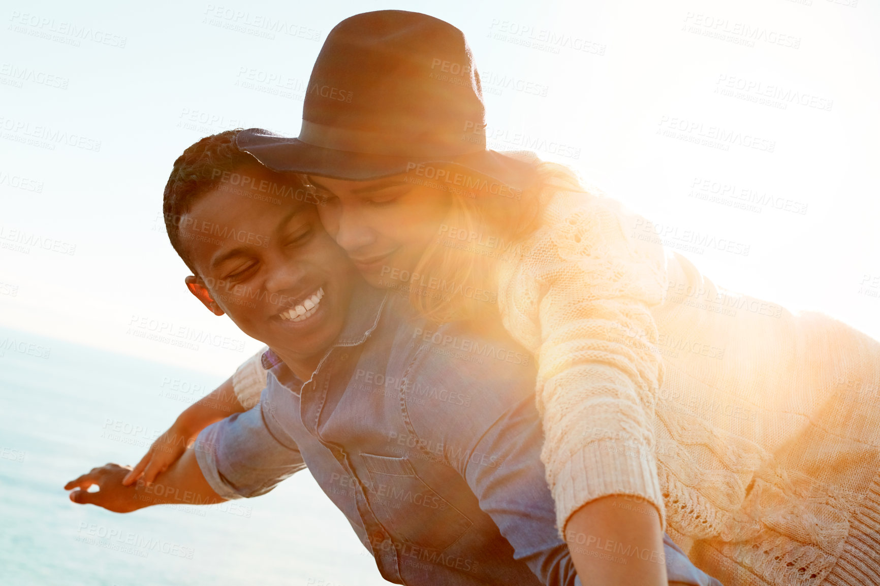 Buy stock photo Shot of a happy young couple enjoying a piggyback ride outdoors