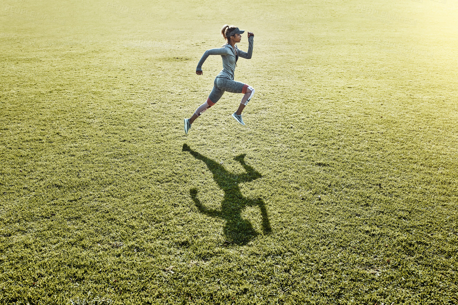 Buy stock photo Full length shot of an attractive and athletic young woman running across an open field
