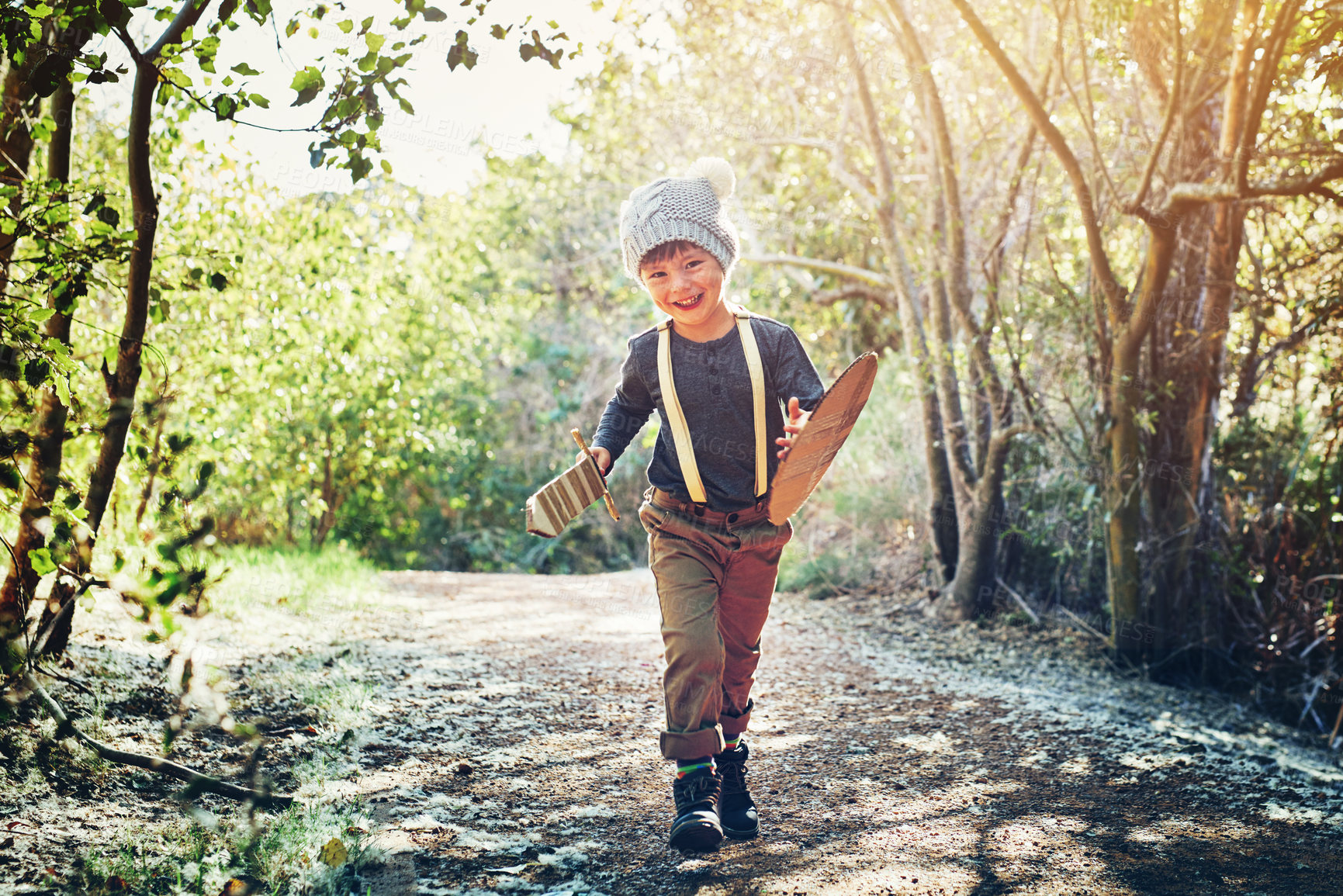 Buy stock photo Cardboard, sword and shield with child in portrait for imagination, fun and playful adventure in forest. Happy, knight and little boy with pretend weapon in woods for combat, battle and fantasy quest