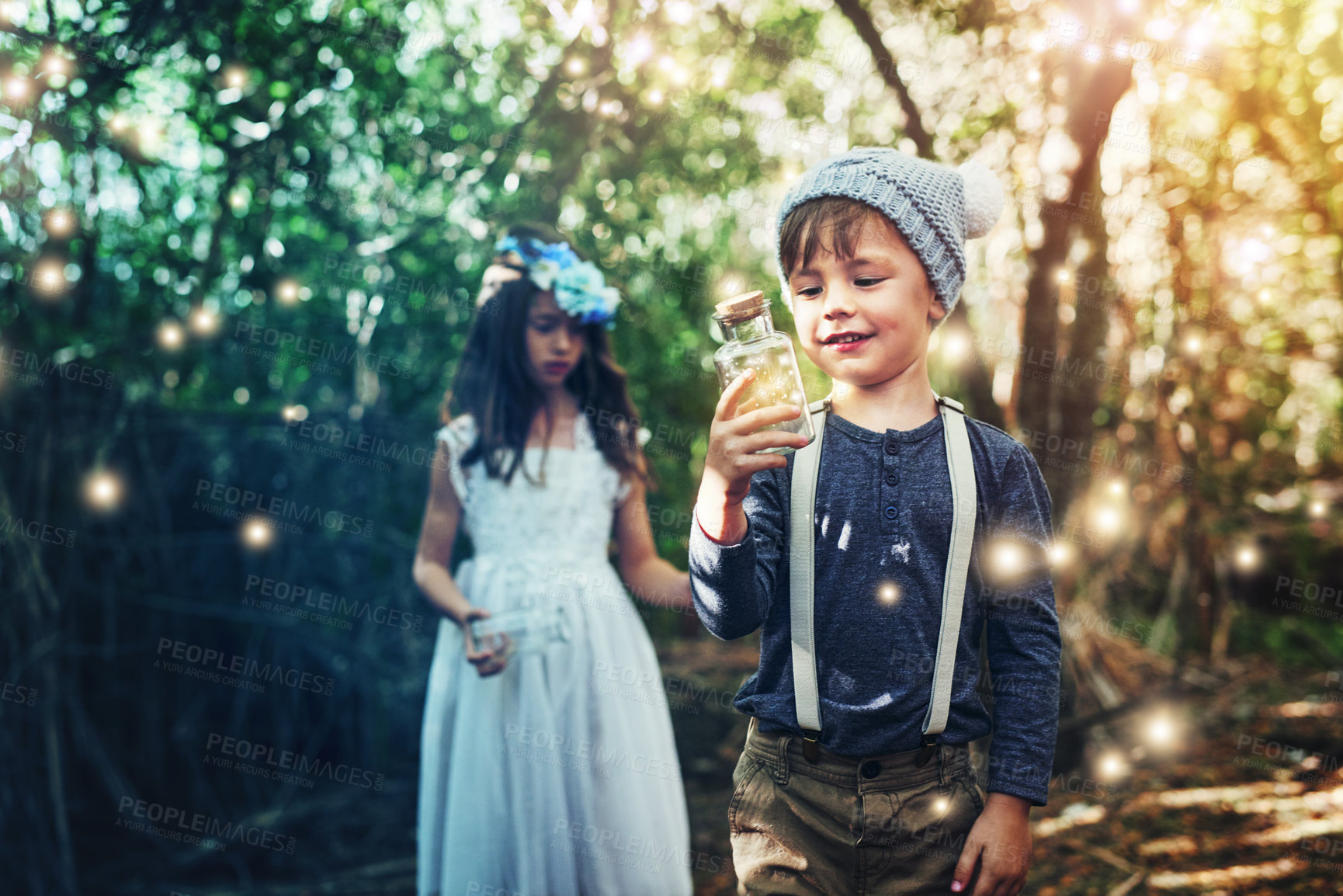 Buy stock photo Shot of two little siblings catching fireflies in jars outside