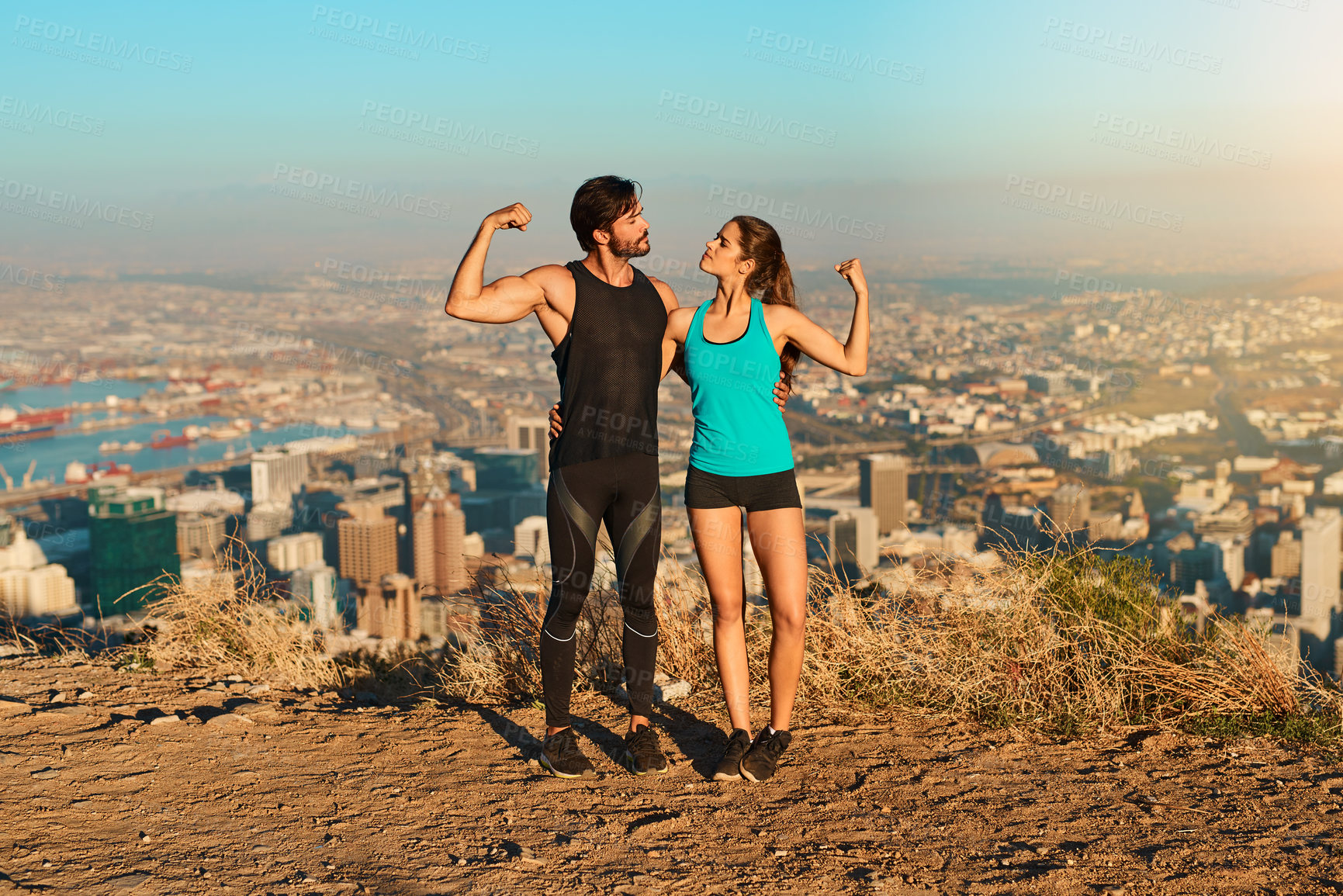Buy stock photo Full length shot of a young couple flexing their muscles while out for a workout