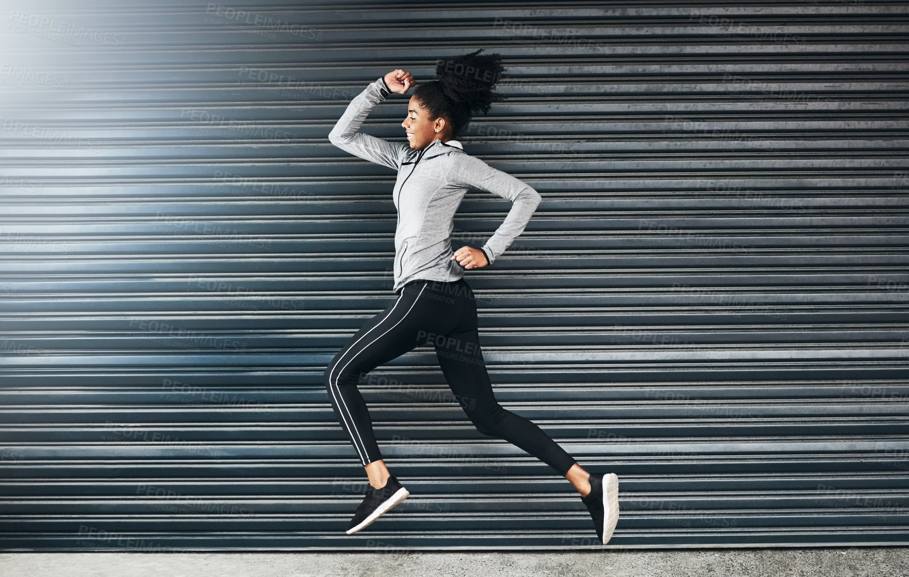 Buy stock photo Shot of a sporty young woman running against a grey background