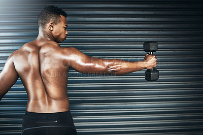 Buy stock photo Rearview shot of a muscular young man lifting weights against a grey background
