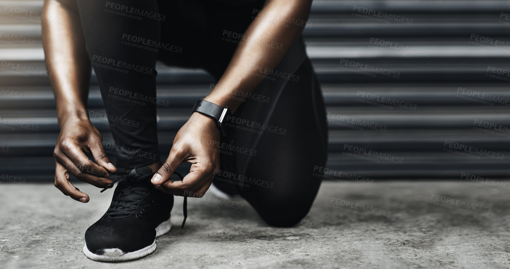 Buy stock photo Closeup shot of a sporty man tying his shoelaces while exercising against a grey background