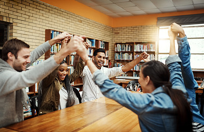 Buy stock photo Cropped portrait of a young male university student and his friends cheering while studying at a table in the library