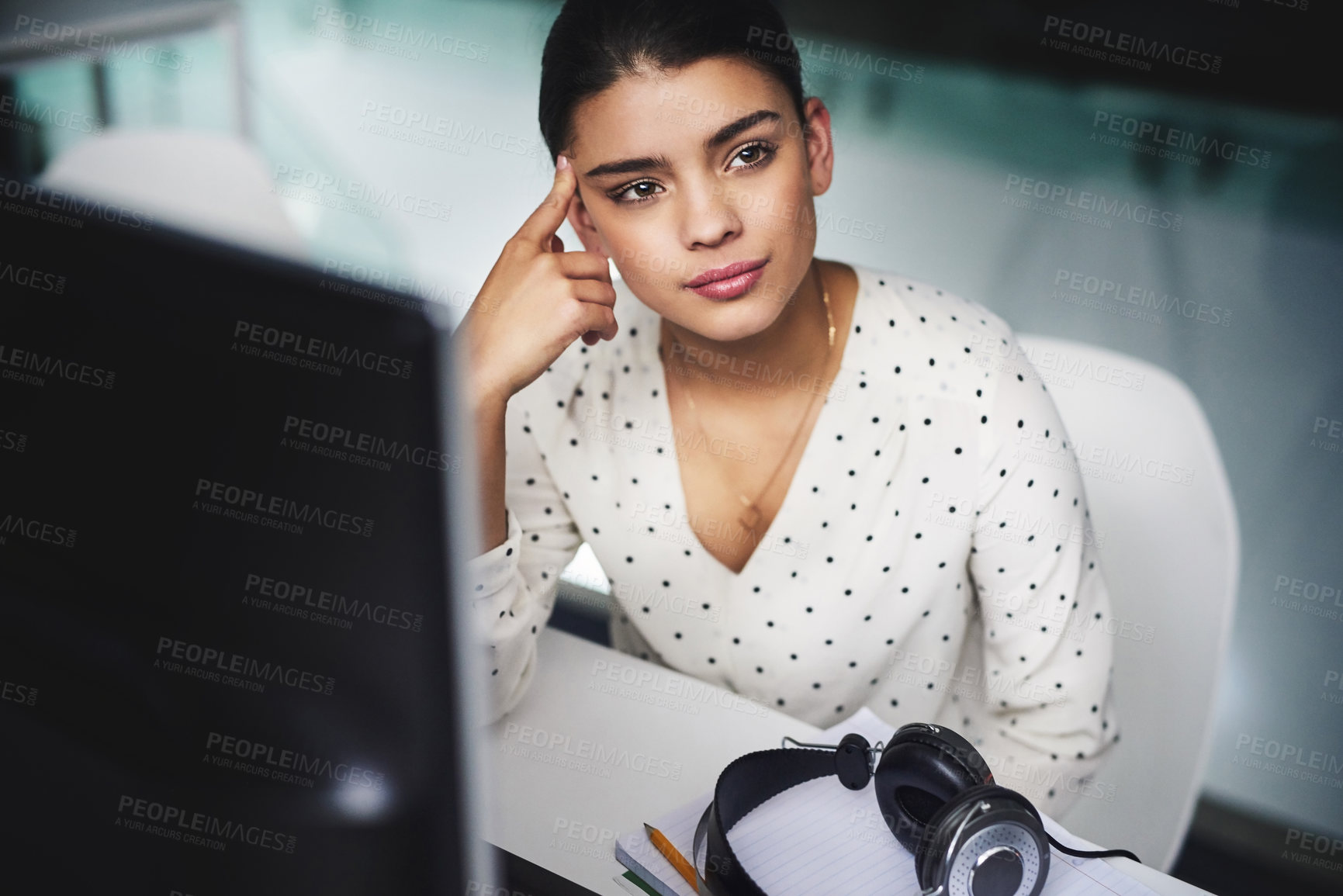 Buy stock photo Cropped shot of an attractive young businesswoman looking bored while working late in a call center