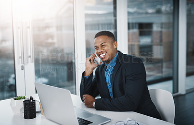 Buy stock photo Shot of a handsome young businessman talking on a cellphone while working in an office